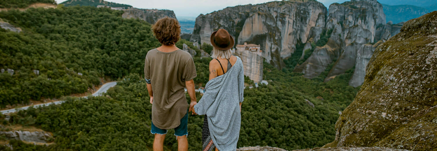 Couple standing on mountain top staring into distance