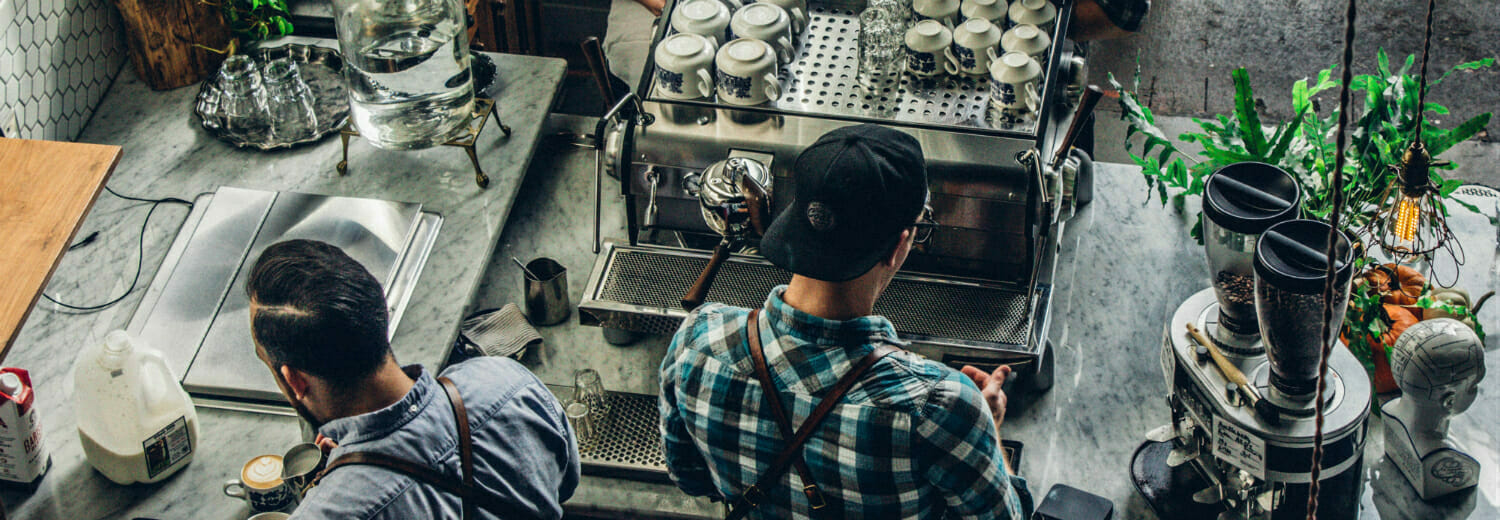 2 Baristas at work in cafe, making coffee