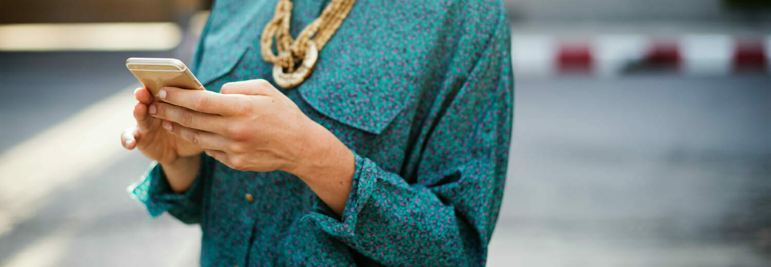 Closeup of woman's hand texting on mobile phone