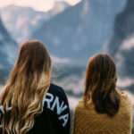 Backs of two women in mountains staring out