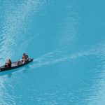 Overhead shot of People canoeing on bright blue lake