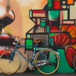 Bikes leaning up against a colourful graffiti wall