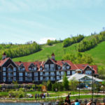Blue Mountain village in the summertime. View of village, hotels, and grassy hill.
