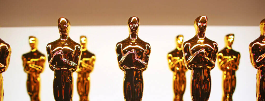 A row of shiny Oscar statuettes