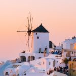 Greek Island white houses set against a pink and orange sunset